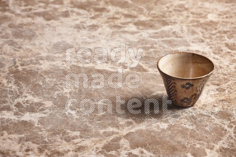 A decorative pottery bowl on beige marble background