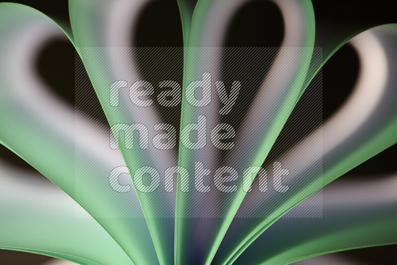 An abstract art piece displaying smooth curves in white and green gradients created by colored light