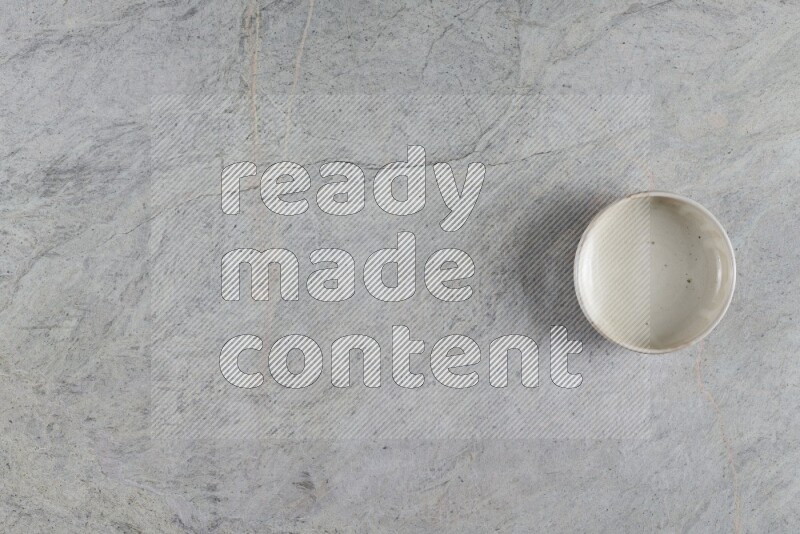 A white pottery bowl on grey marble background