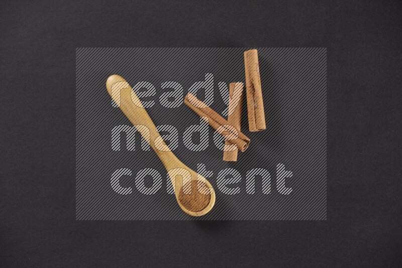 3 Cinnamon sticks stacked beside a wooden spoon full of cinnamon powder on black background in different angles