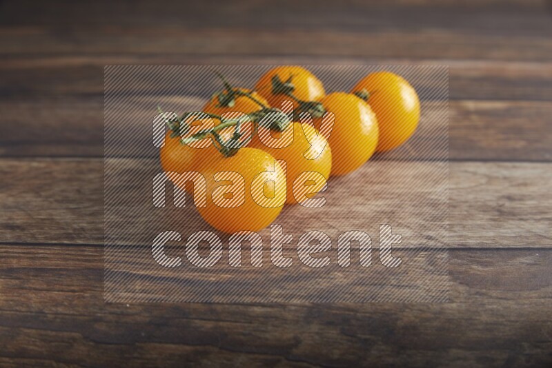 yellow cherry tomato vein on a textured wooden background 45 degree