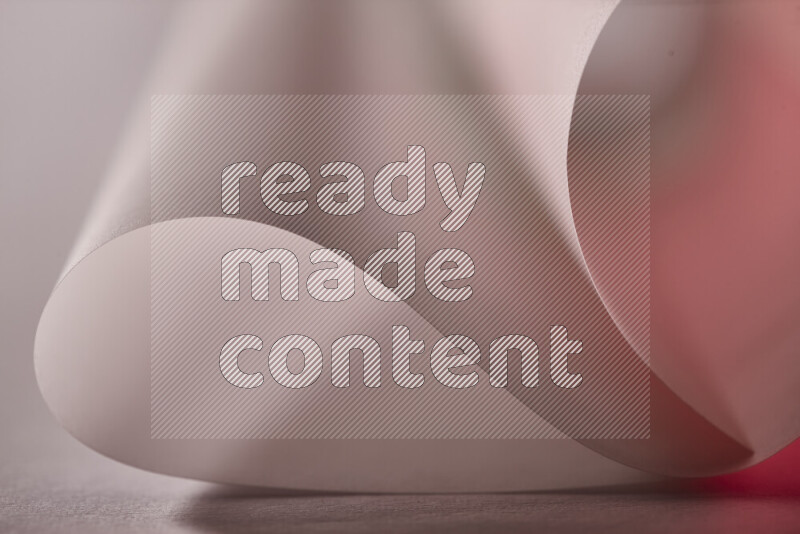 An abstract art piece displaying smooth curves in red and grey gradients created by colored light