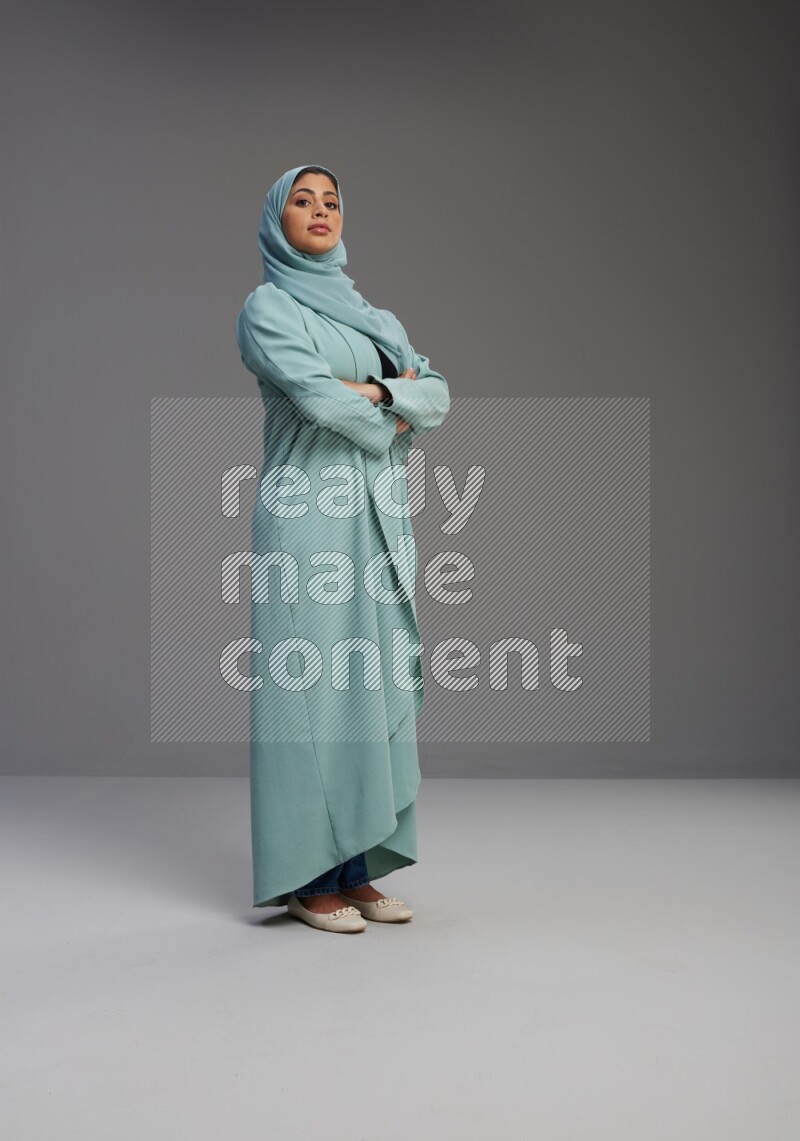 Saudi Woman wearing Abaya standing with crossed arms on Gray background