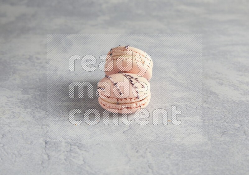 45º Shot of two pink orange blossom macarons  on white  marble background