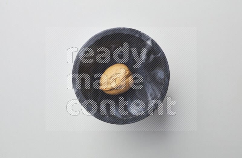 Top-view shot of walnut in a container on white background
