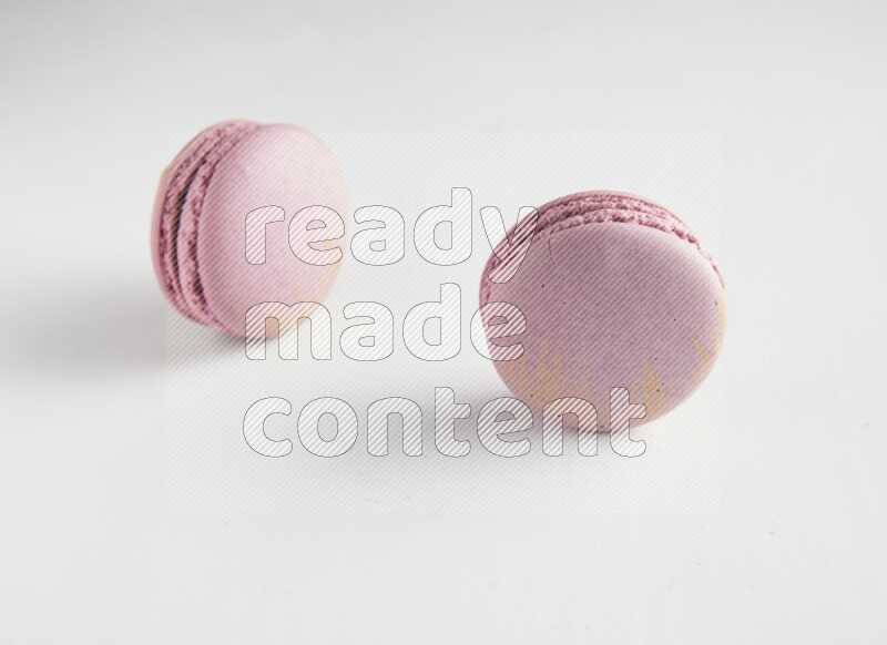 45º Shot of two Purple Strawberry macarons on white background