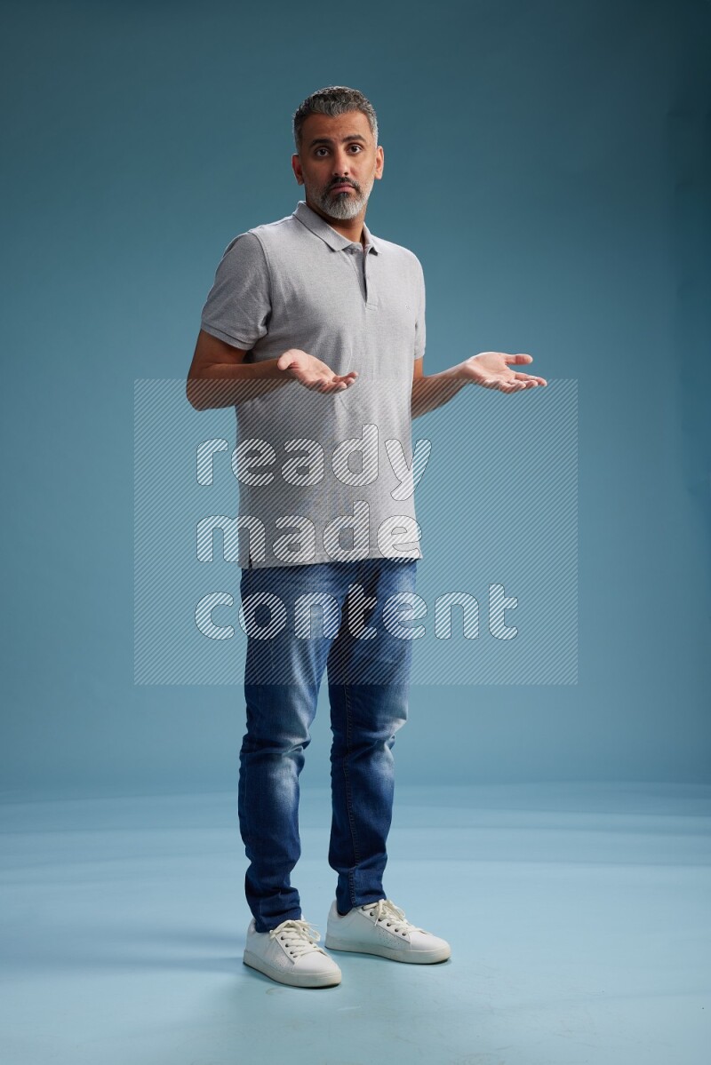 Man Standing Interacting with the camera on blue background