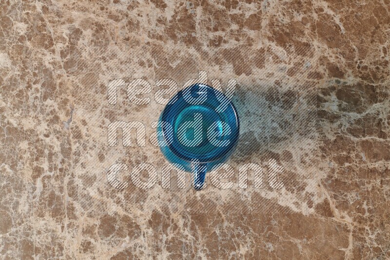 A colored glass jug on beige marble background
