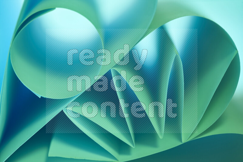 An artistic display of paper folds creating a harmonious blend of geometric shapes, highlighted by soft lighting in green and blue tones