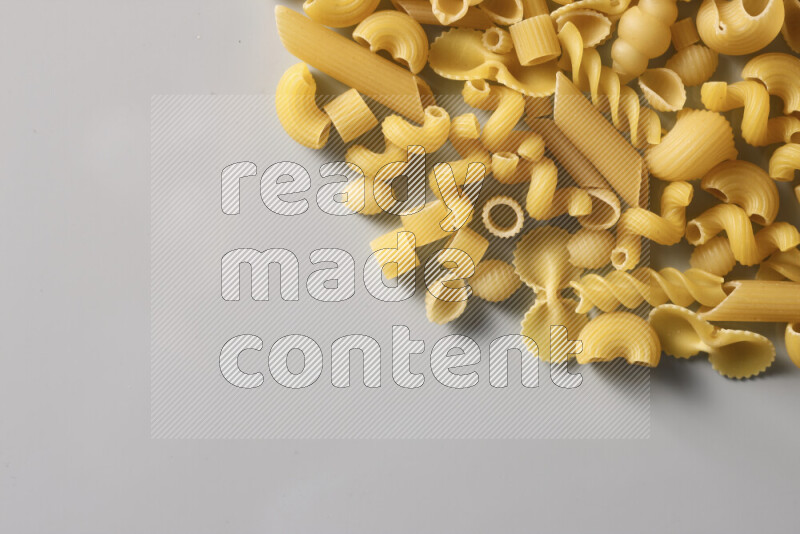 Different pasta types on light blue background