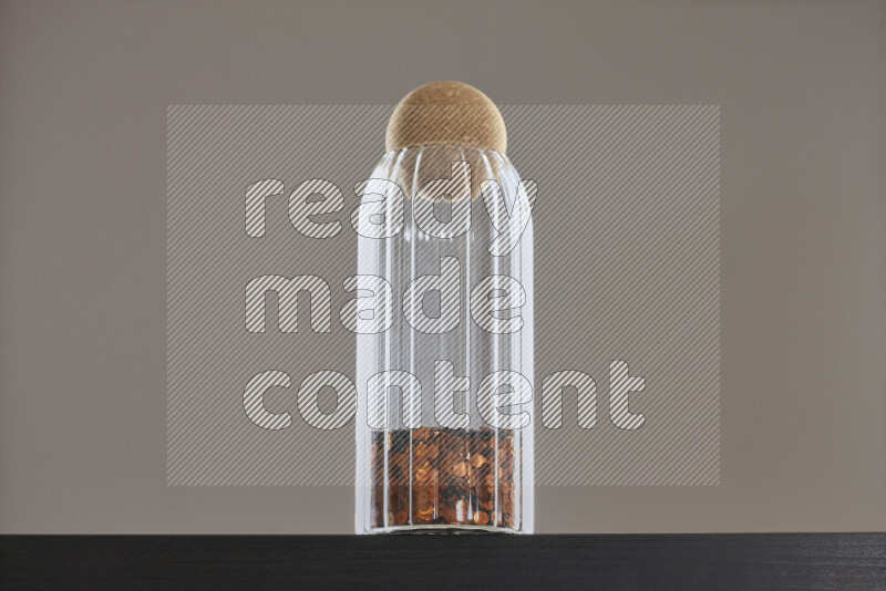 Sequins in a glass jar on black background