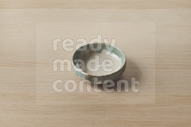 وعاء فخاري متعدد الألوان على خلفية خشبية فاتحة