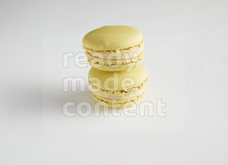 45º Shot of two Yellow Lime macarons on white background
