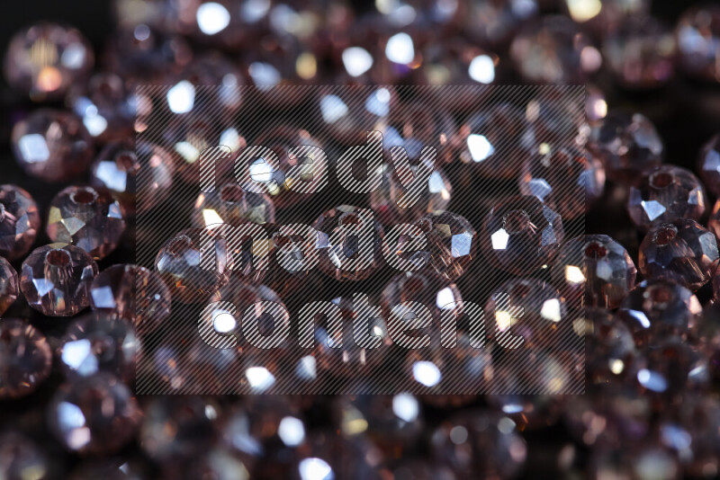 Rose transparent crystal beads scattered on a black background