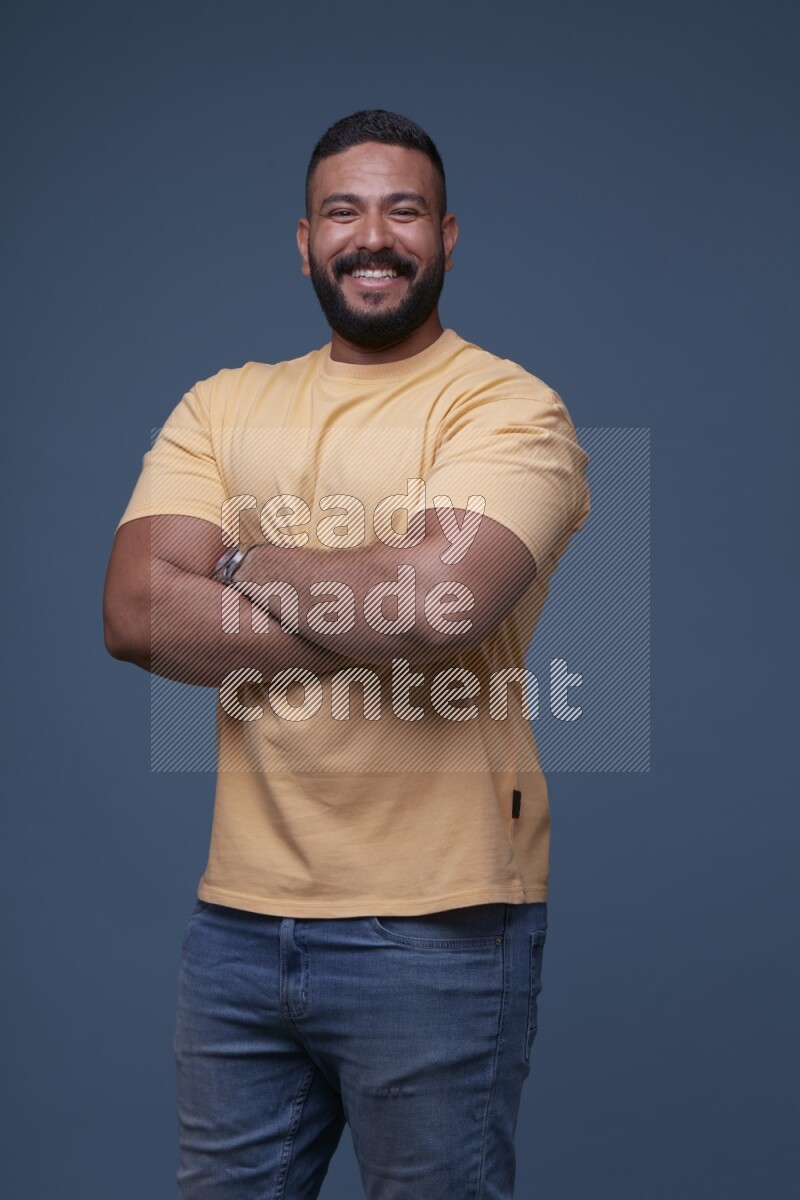 رجل يرتدي قميص اصفر بأكمام قصيرة وبنطال جينز ازرق يقف بأوضاع مختلفة