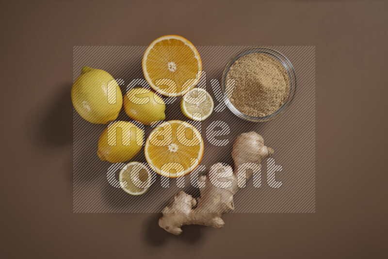 Fresh ginger root with different ingredients such as lemon, orange, honey, ground ginger on beige baackground