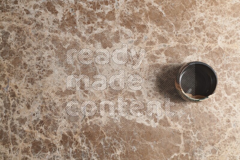 وعاء فخاري متعدد الألوان على خلفية من الرخام البيج