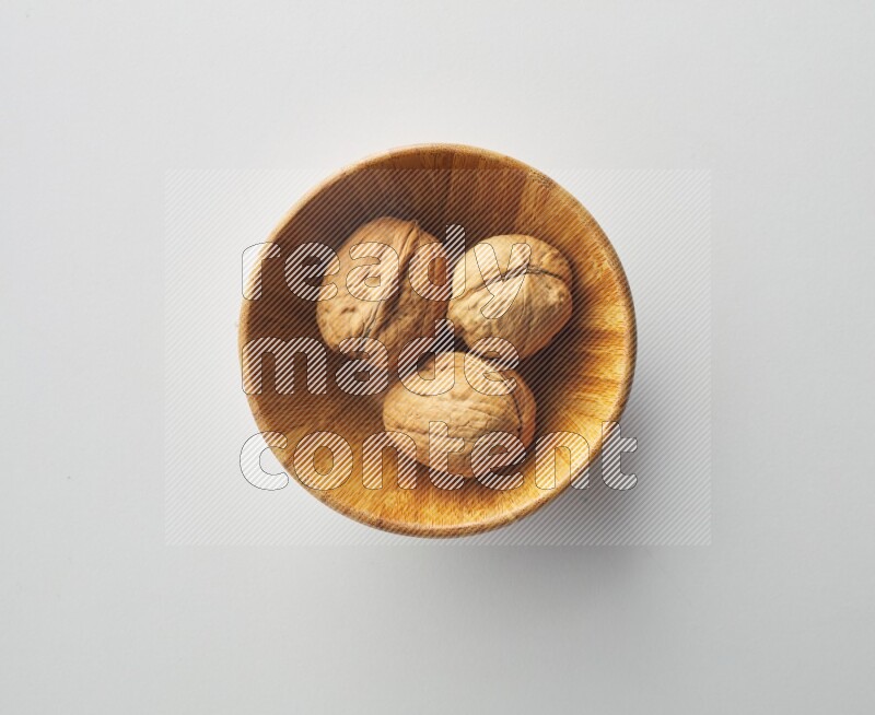 Top-view shot of walnut in a container on white background