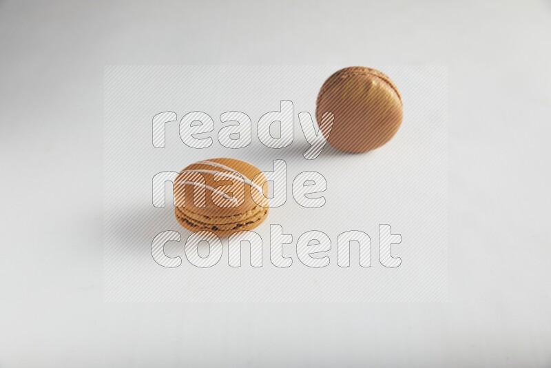 45º Shot of of two assorted Brown Irish Cream, and Brown Coffee macarons  on white background