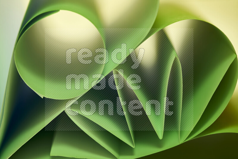 عرض فني لطيات الورق تخلق مزيج من الأشكال الهندسية، مضاءة بإضاءة ناعمة بدرجات اللون الأخضر