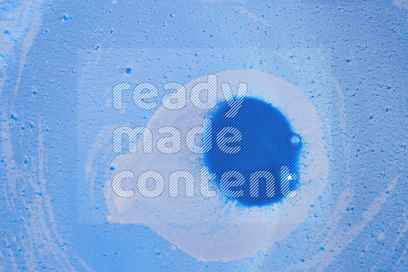 تلتقط الصورة تناثرا للطلاء الأزرق علي خلفية زرقاء