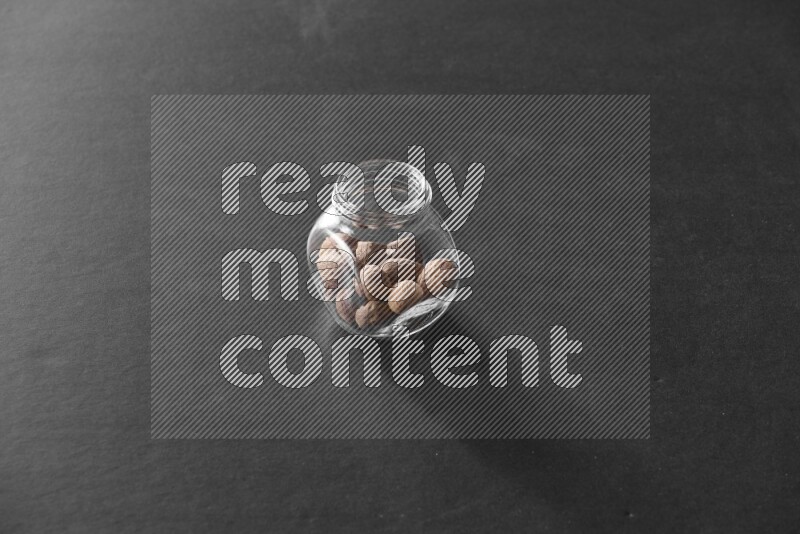 جوزة الطيب في وعاء زجاجي علي خلفية سوداء