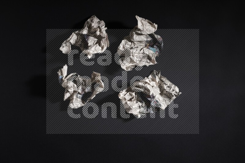 Crumpled newspaper sheet on black background