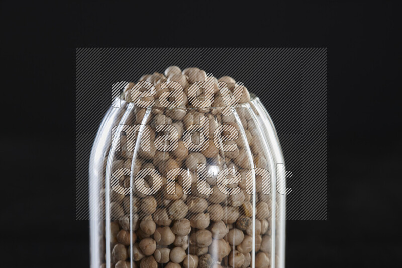 Chickpeas in a glass jar on black background