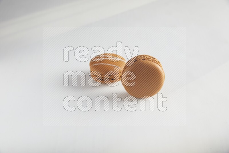 45º Shot of of two assorted Brown Irish Cream, and Brown Maple Taffy macarons  on white background
