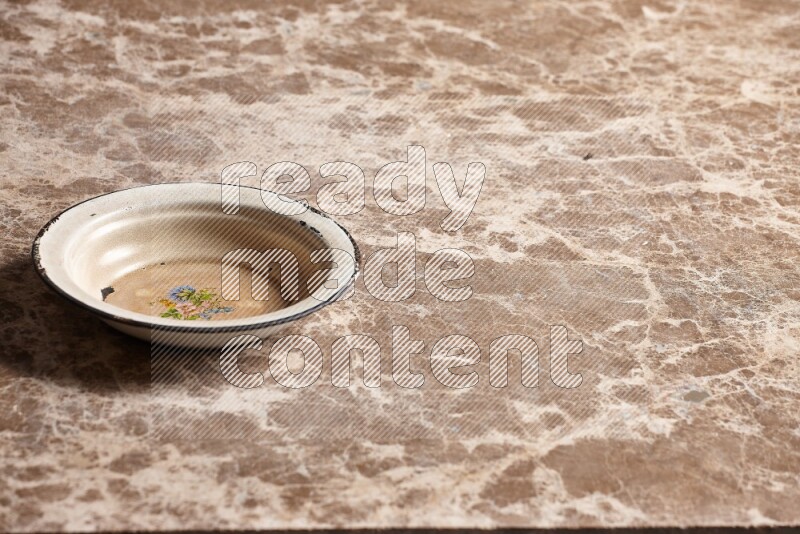 A vintage metal plate on beige marble background