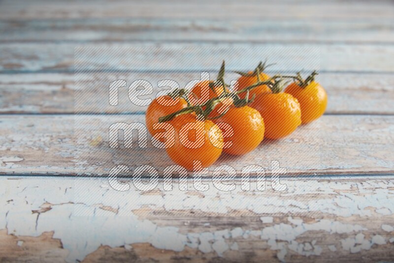 orange cherry tomato vein on a textured blue wooden background 45 degree