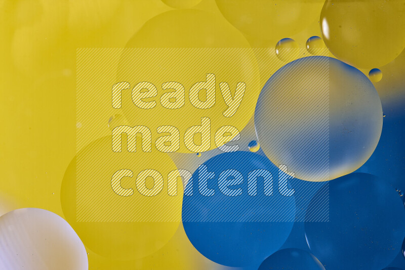 Close-ups of abstract oil bubbles on water surface in shades of blue and yellow