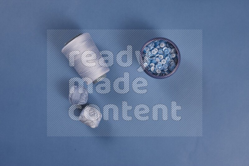 مجموعة من أدوات الخياطة والتفصيل زرقاء اللون على خلفية زرقاء