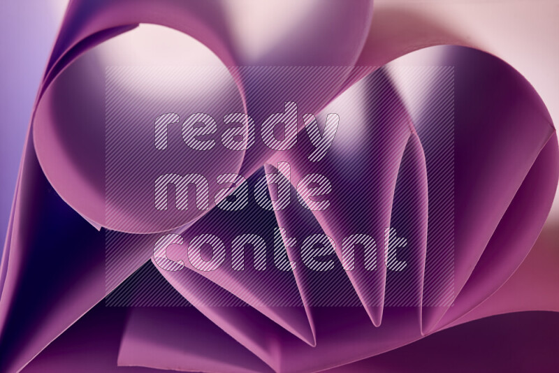 An artistic display of paper folds creating a harmonious blend of geometric shapes, highlighted by soft lighting in purple tones