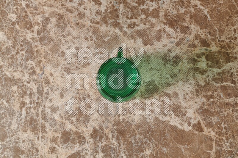 A colored glass jug on beige marble background