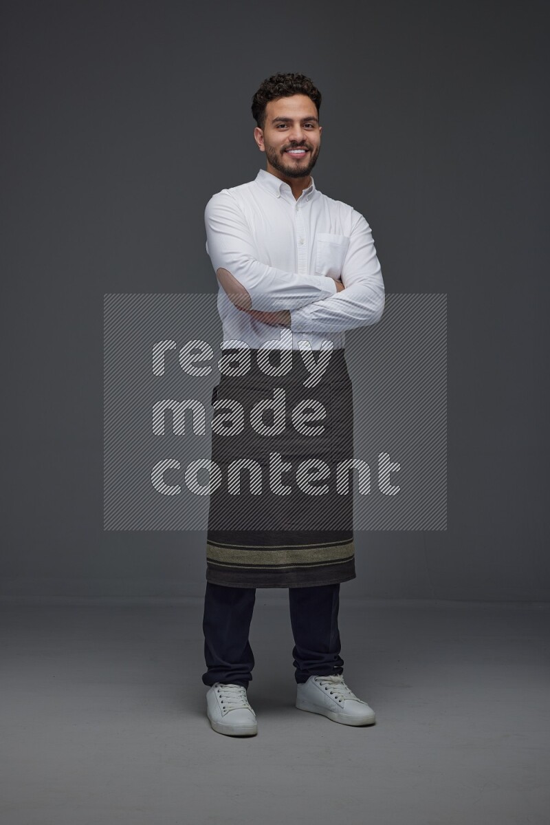 A man wearing smart casual and apron standing and making multi poses eye level on a gray background