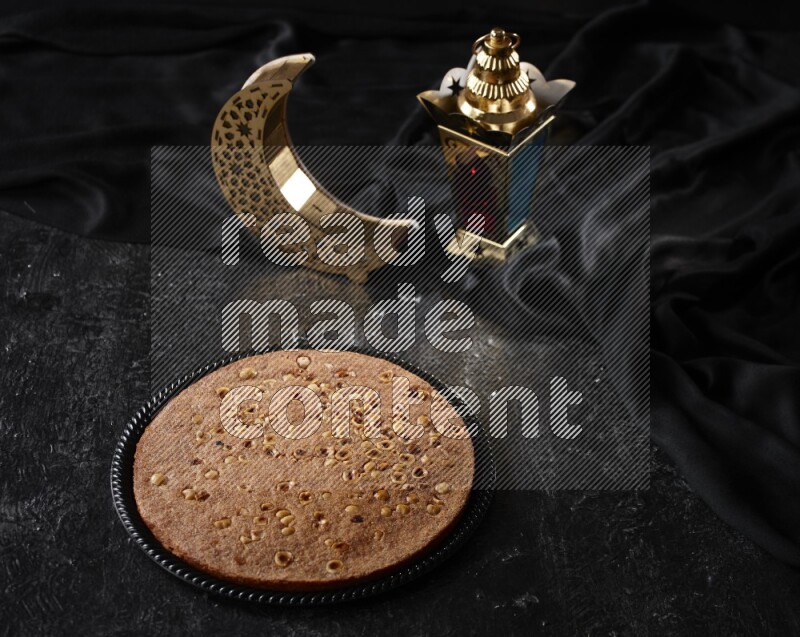 بسبوسة مع فوانيس علي خلفية سوداء خشبية