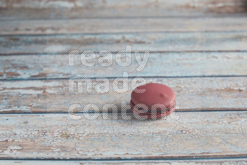 45º Shot of Red Cherry macaron on light blue wooden background