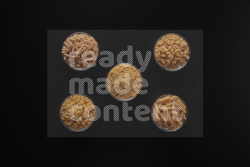 أنواع مختلفة من المعكرونة في أوعية زجاجية علي خلفية سوداء