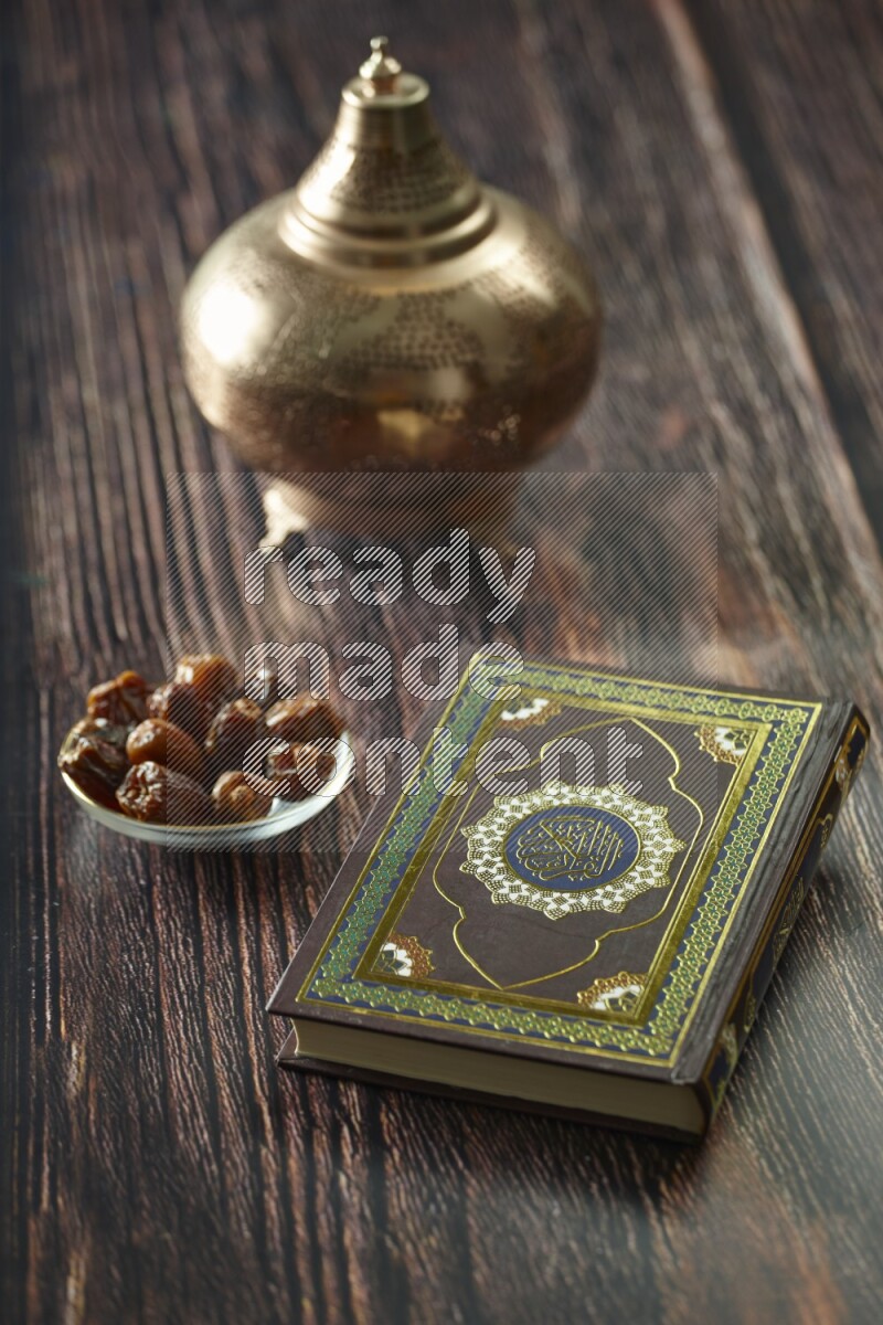 A golden lantern with different drinks, dates, nuts, prayer beads and quran on brown wooden background