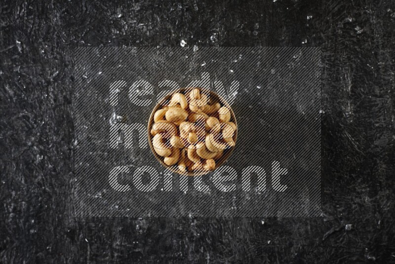 مكسرات في وعاء معدني علي خلفية سوداء