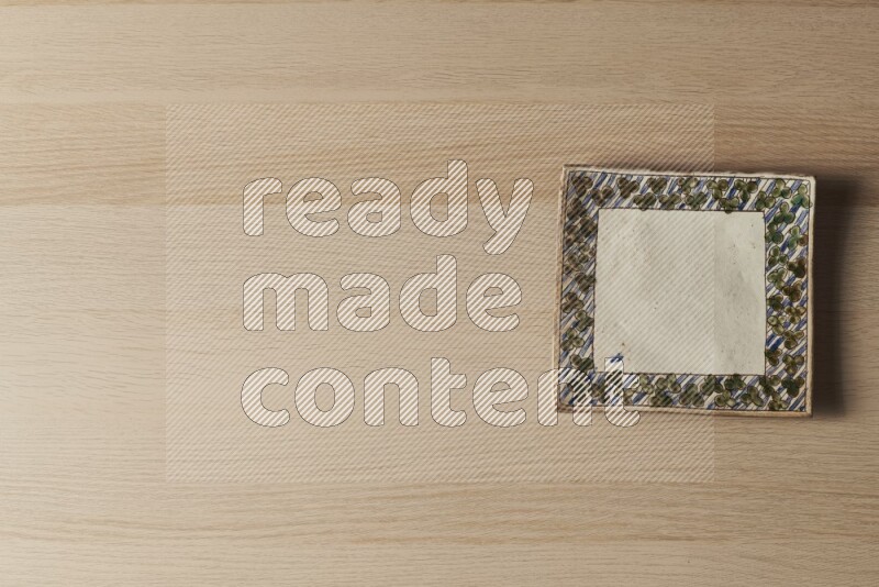 A decorative pottery plate on light wooden background