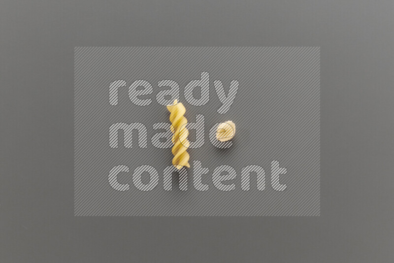 Shells pasta with other types of pasta on grey background