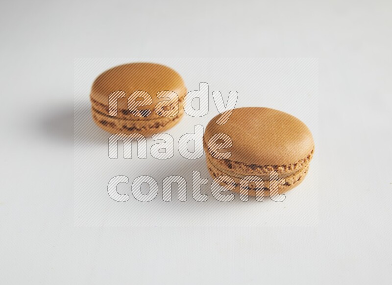 45º Shot of two Brown Maple Taffy macarons on white background