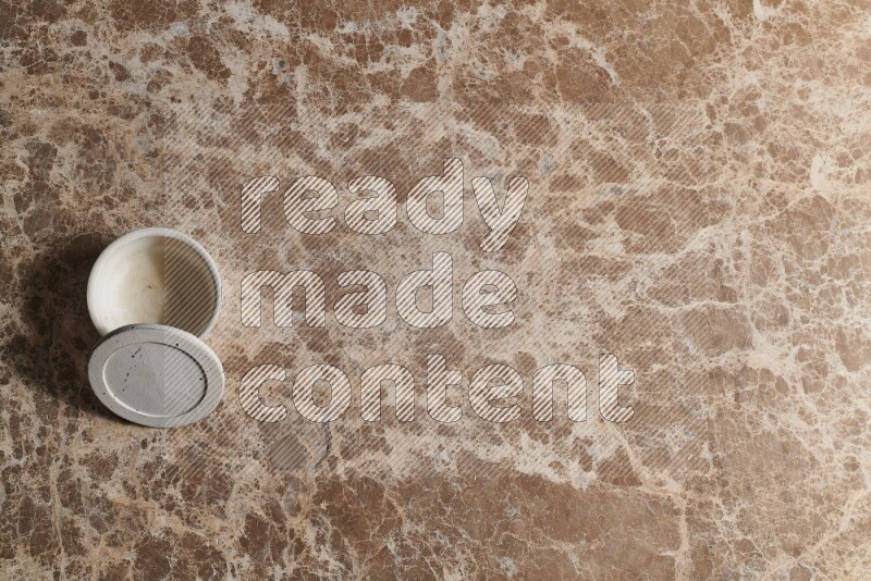 A pottery cup on beige marble background
