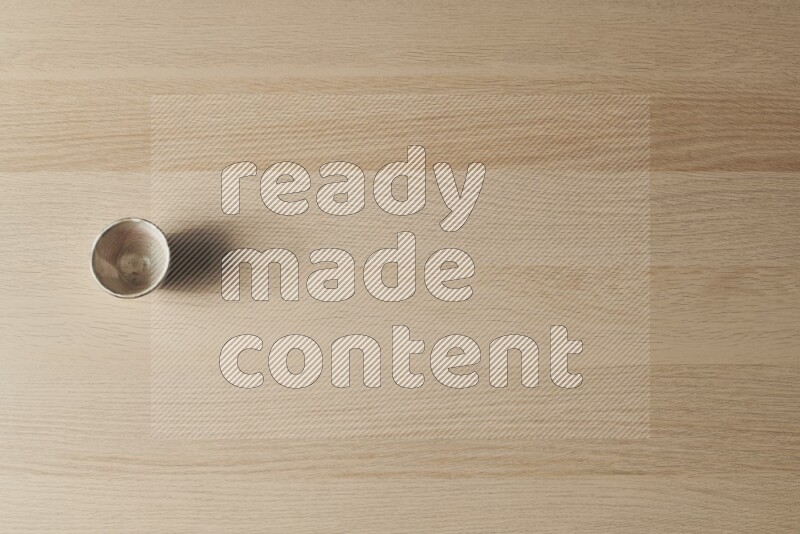 A pottery cup on light wooden background