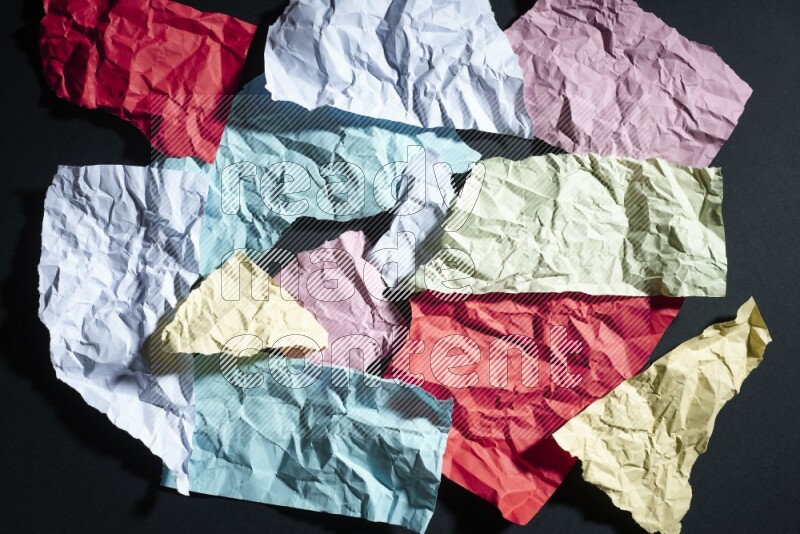 Crumpled multicolored paper on black background