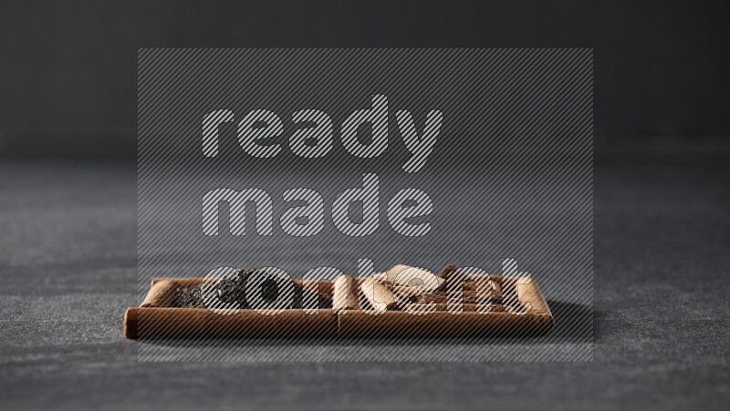 مربعان من أعواد القرفة ممتلئان بالشاي والقرفة علي خلفية سوداء