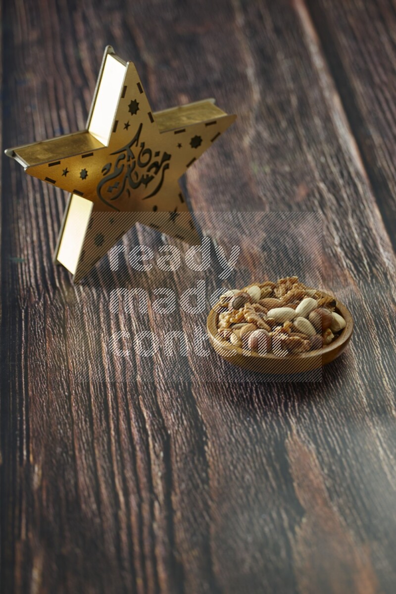 A wooden golden star lantern with different drinks, dates, nuts, prayer beads and quran on brown wooden background