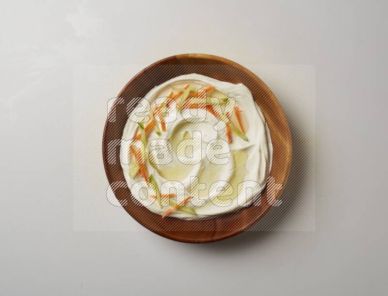 Lebnah garnished with sliced carrots & cucumber in a wooden plate on a white background